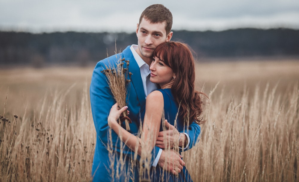 a man and woman posing for a picture in a field