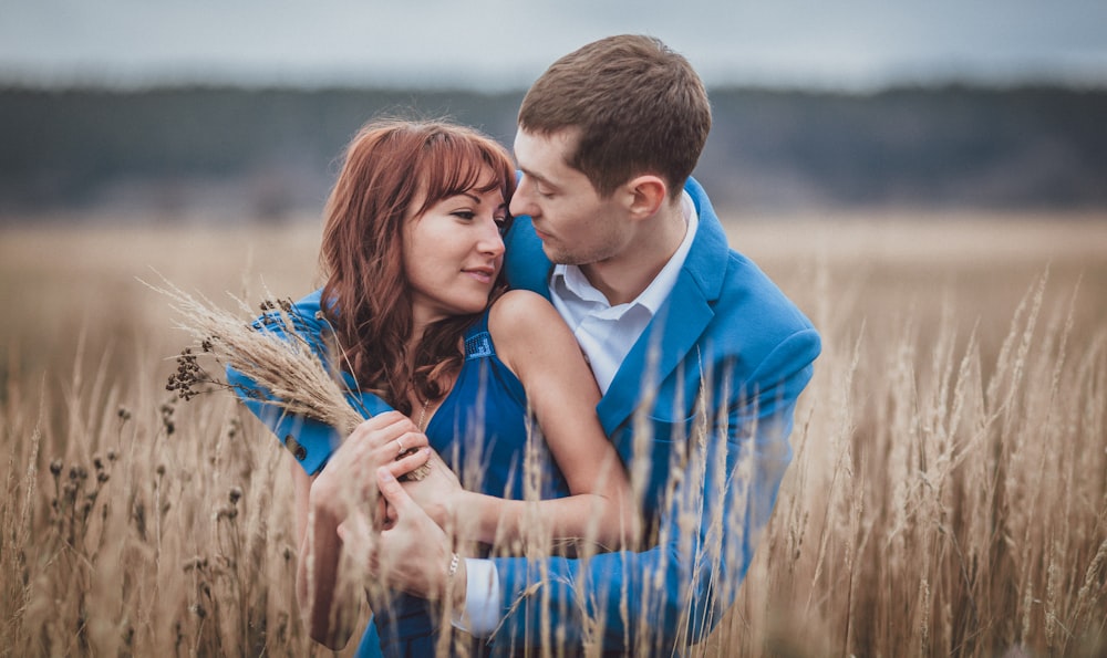 a man and woman kissing in a field of wheat
