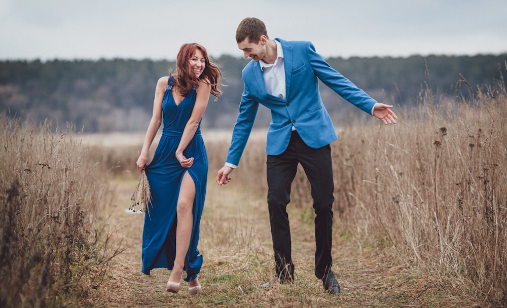 a man and woman holding hands in a field