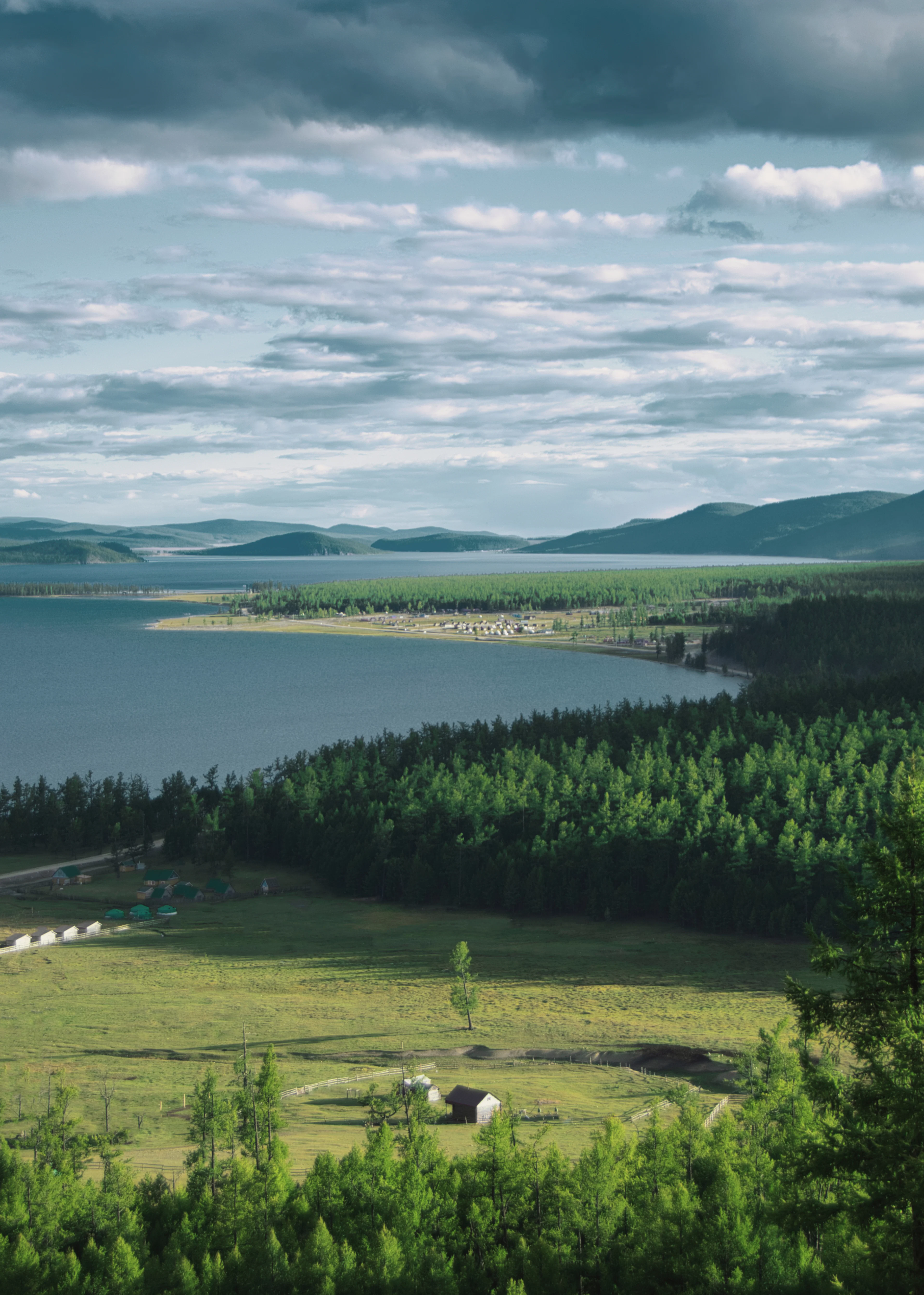 Taiga forest running down to a long blue lake