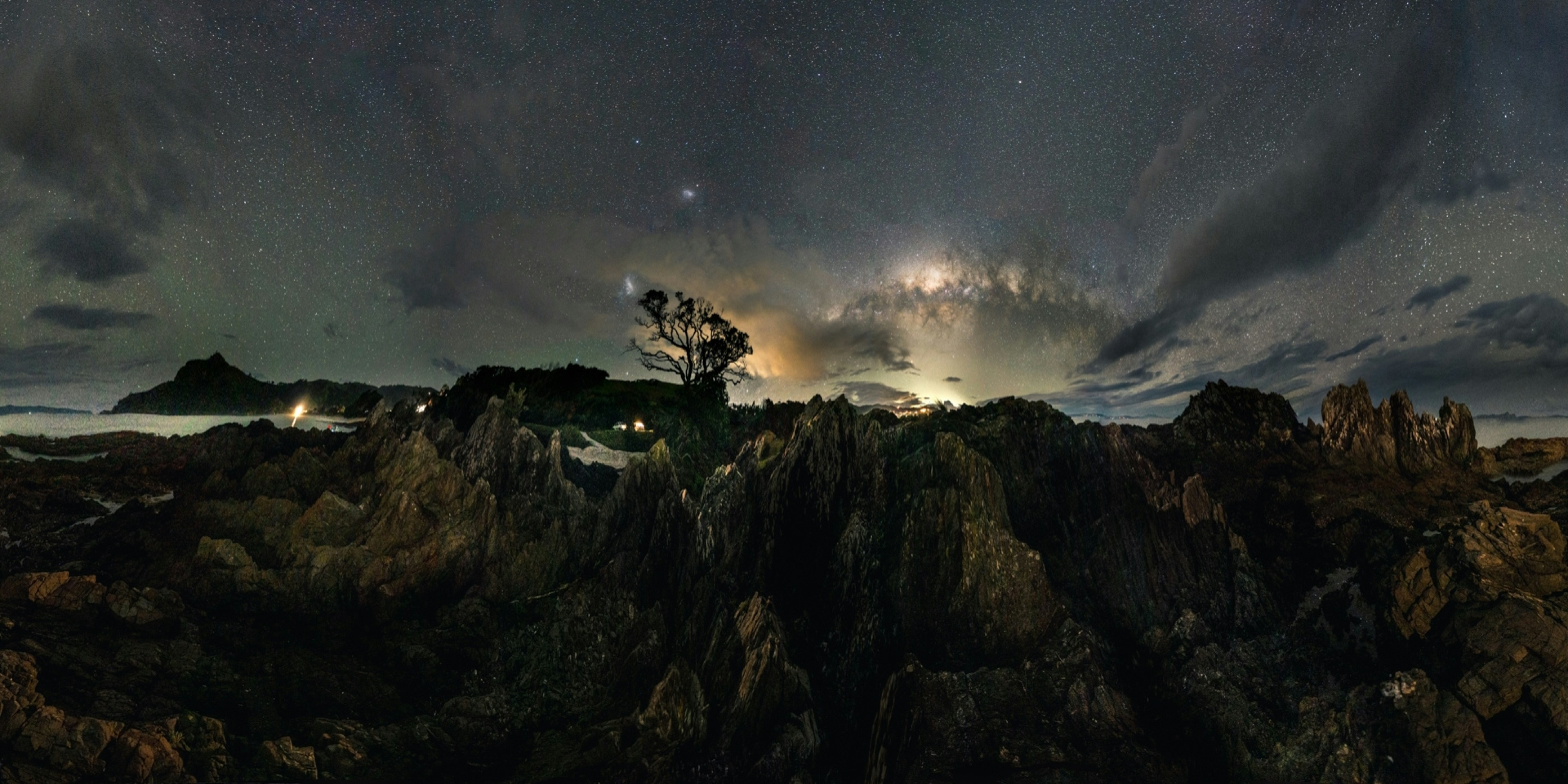 A Milky Way Panorama in New Zealand's ocean This gorgeous rock formation in the ocean in New Zealand is only accessible during low tide. Therefore, the time frame for this shot was quite narrow, as the daylight and some clouds moved the shot towards the incoming/rising water. Nevertheless, it was possible to shoot the 36 images and stitch them together, resulting in this lovely Milky Way Panorama. Despite some minor stitching artefacts, and not having a total 360 view, I am very happy with the result.