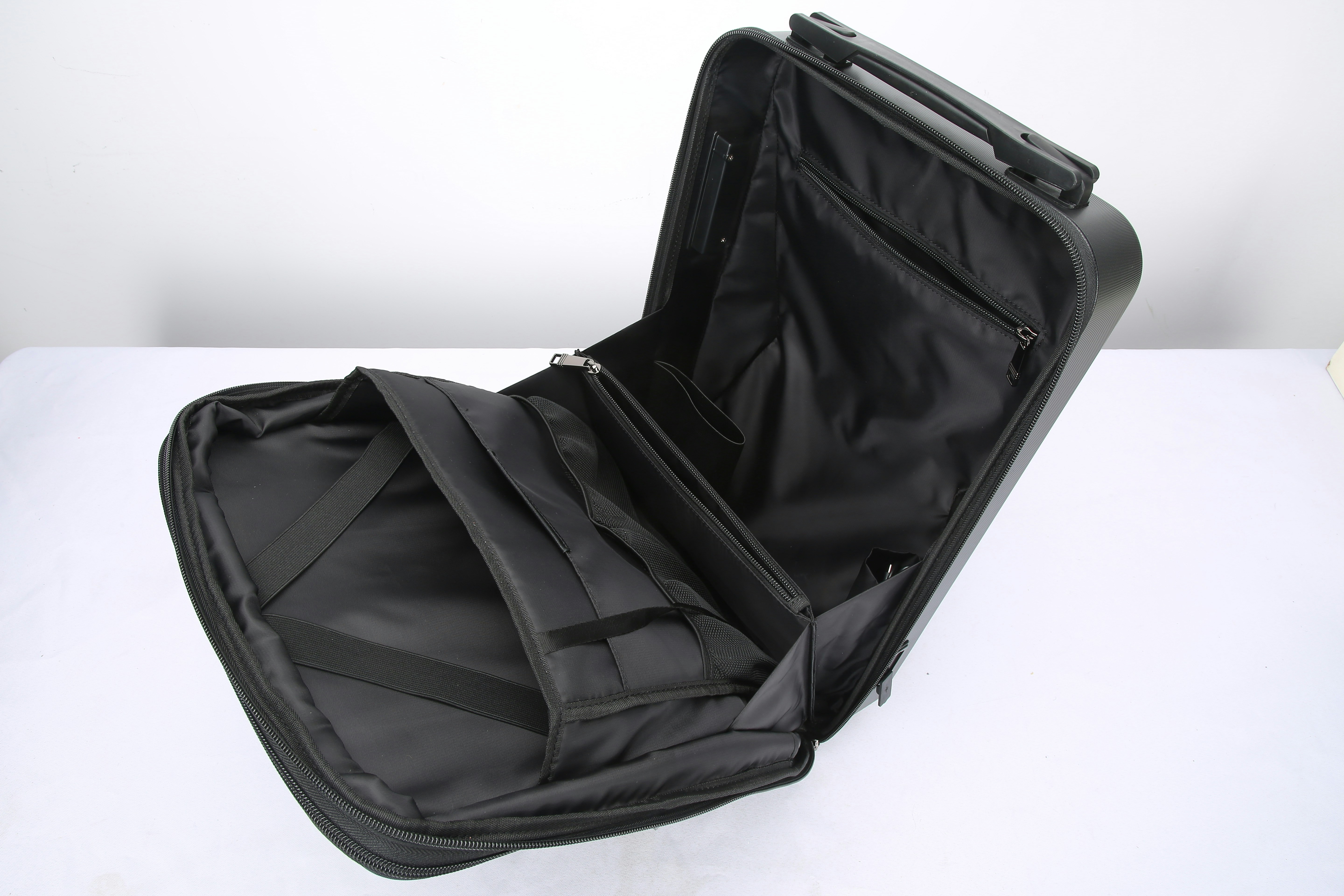 Neatly organised open suitcase on a white bed with folded clothes, passport, and travel accessories laid out methodically