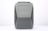 A modern, sleek suitcase with a hard shell design and a matte gray finish. The suitcase features clean lines and a rectangular shape, with a handle on top and subtle patterns that add a touch of style.