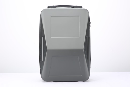 A modern, sleek suitcase with a hard shell design and a matte gray finish. The suitcase features clean lines and a rectangular shape, with a handle on top and subtle patterns that add a touch of style.