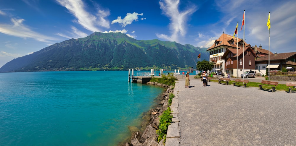 a body of water with a building and a hill in the background