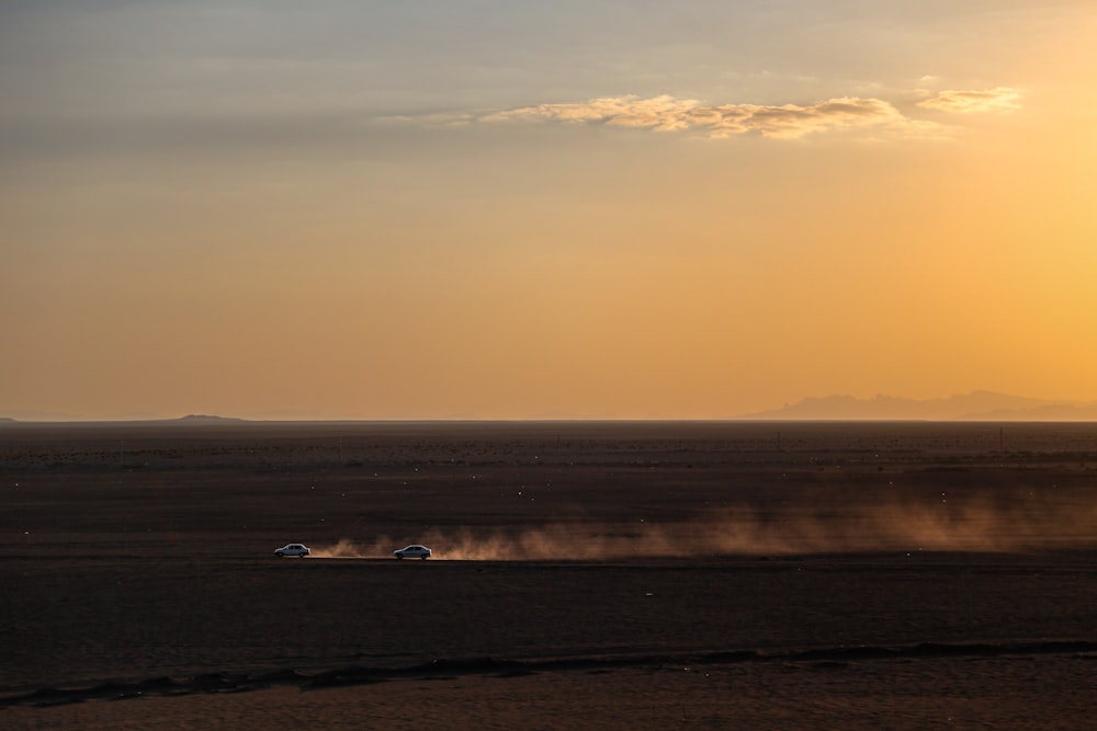 a group of cars driving on a road in the desert