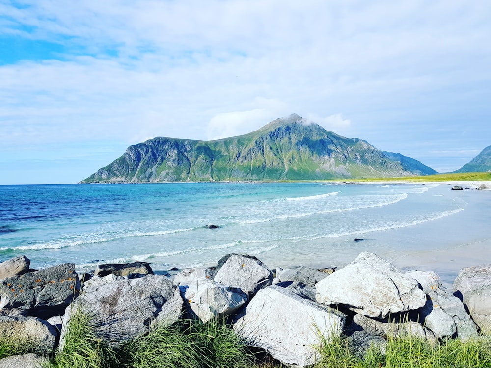 a rocky beach with a mountain in the background