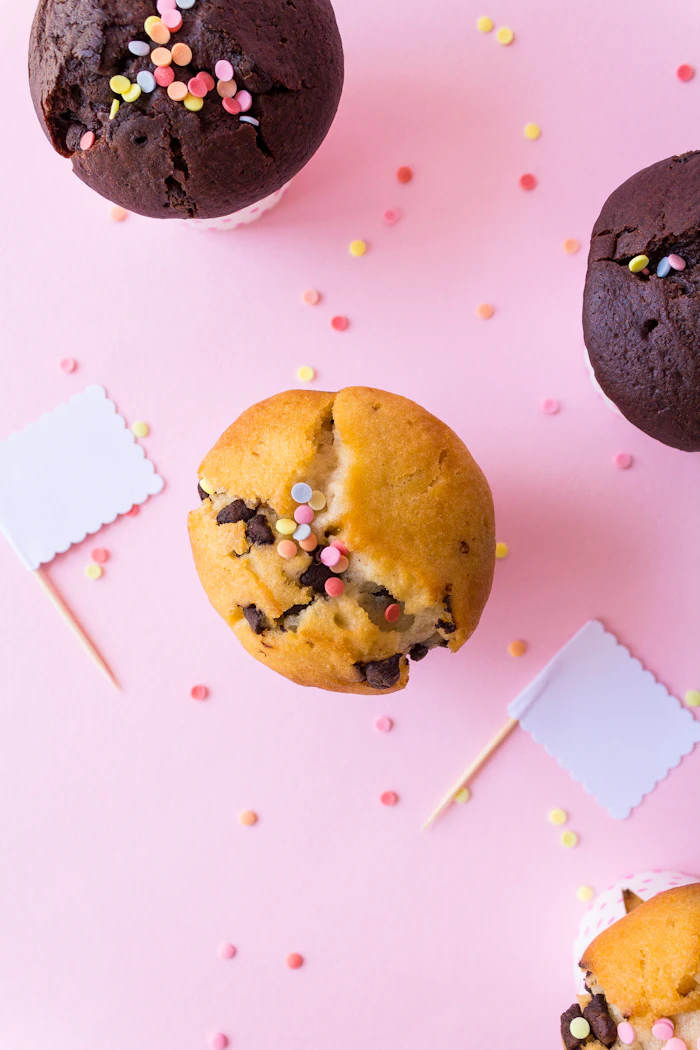 Cupcakes mit Streuseln auf pastellfarbenem Hintergrund