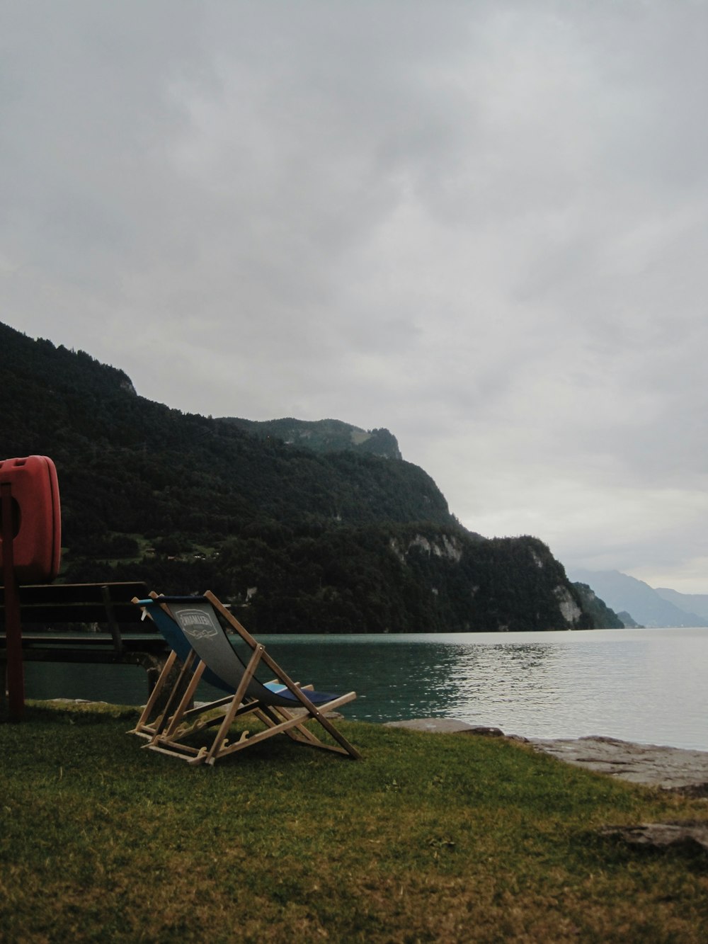 a chair on a grassy hill by a body of water