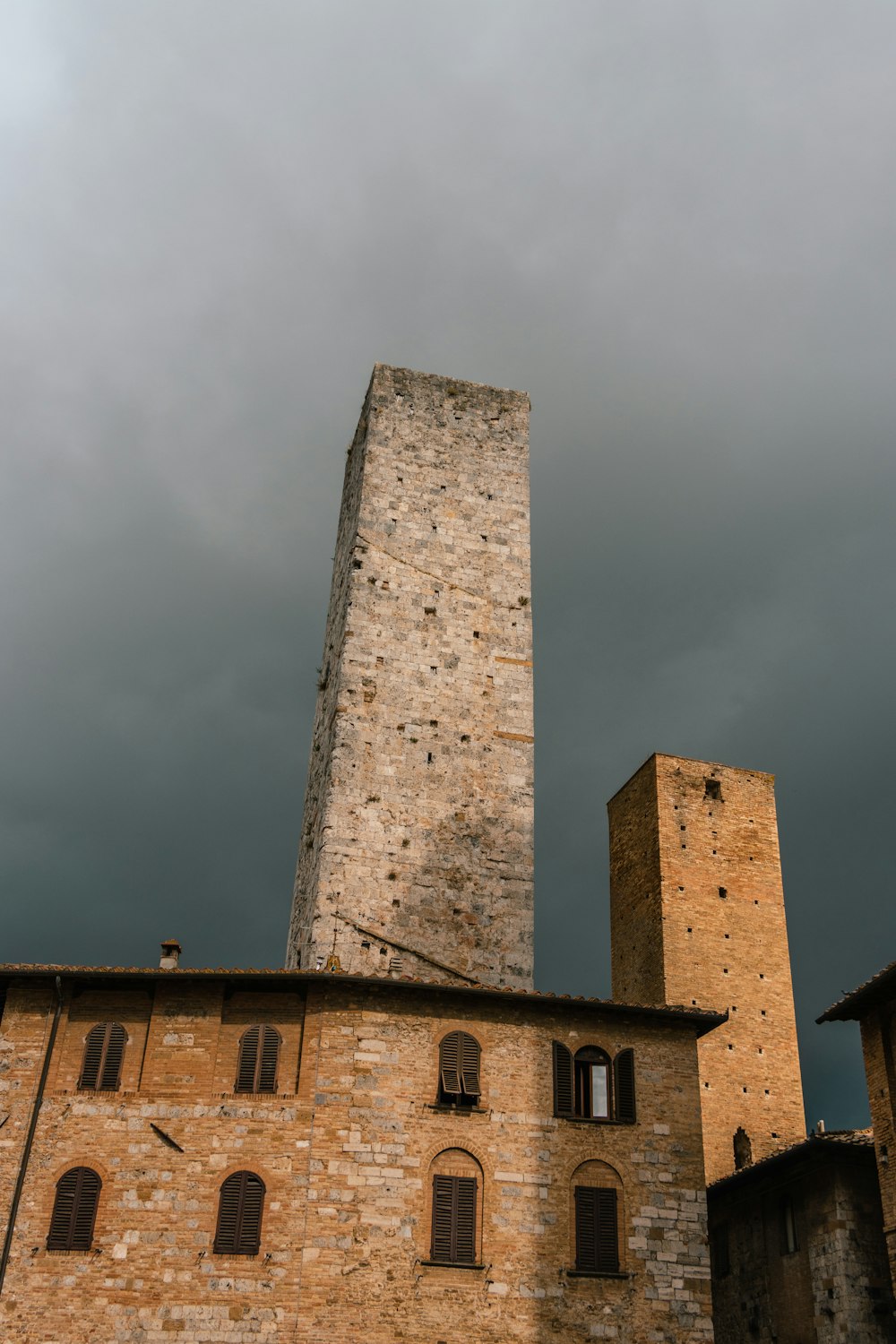 a stone tower with a brick building in the background