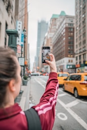 a person taking a picture of a street with a cell phone