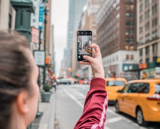 a person taking a picture of a street with a cell phone