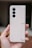 A hand is holding a beige Samsung smartphone with a foldable design. The phone has three rear cameras aligned vertically and a sleek, minimalistic appearance.