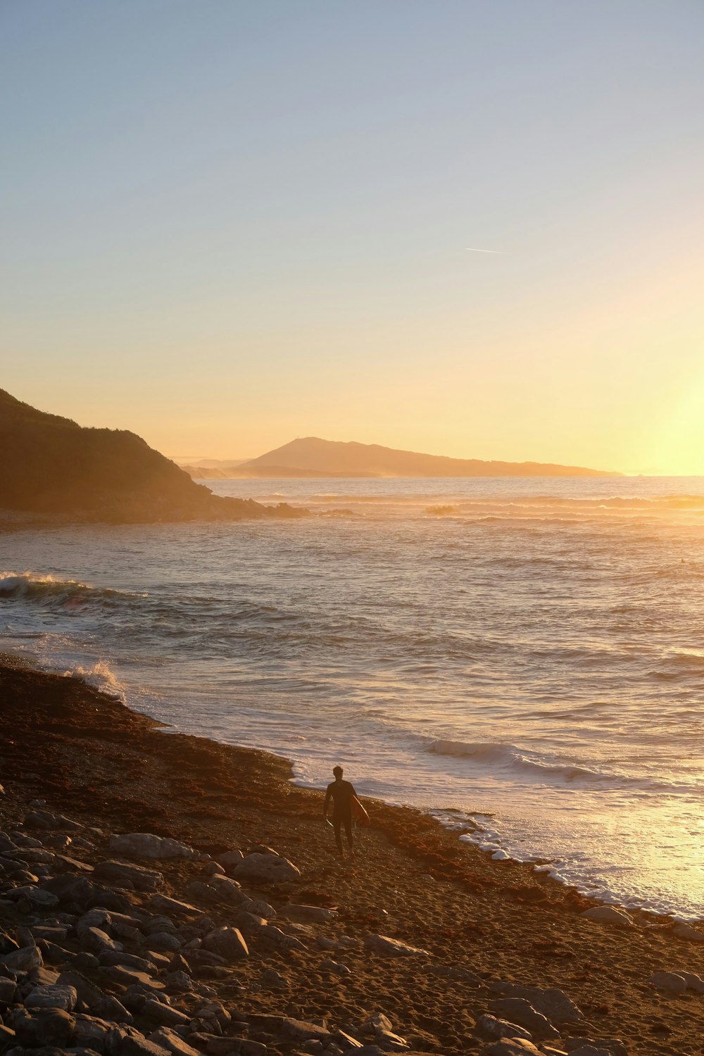 a person standing on a rocky beach