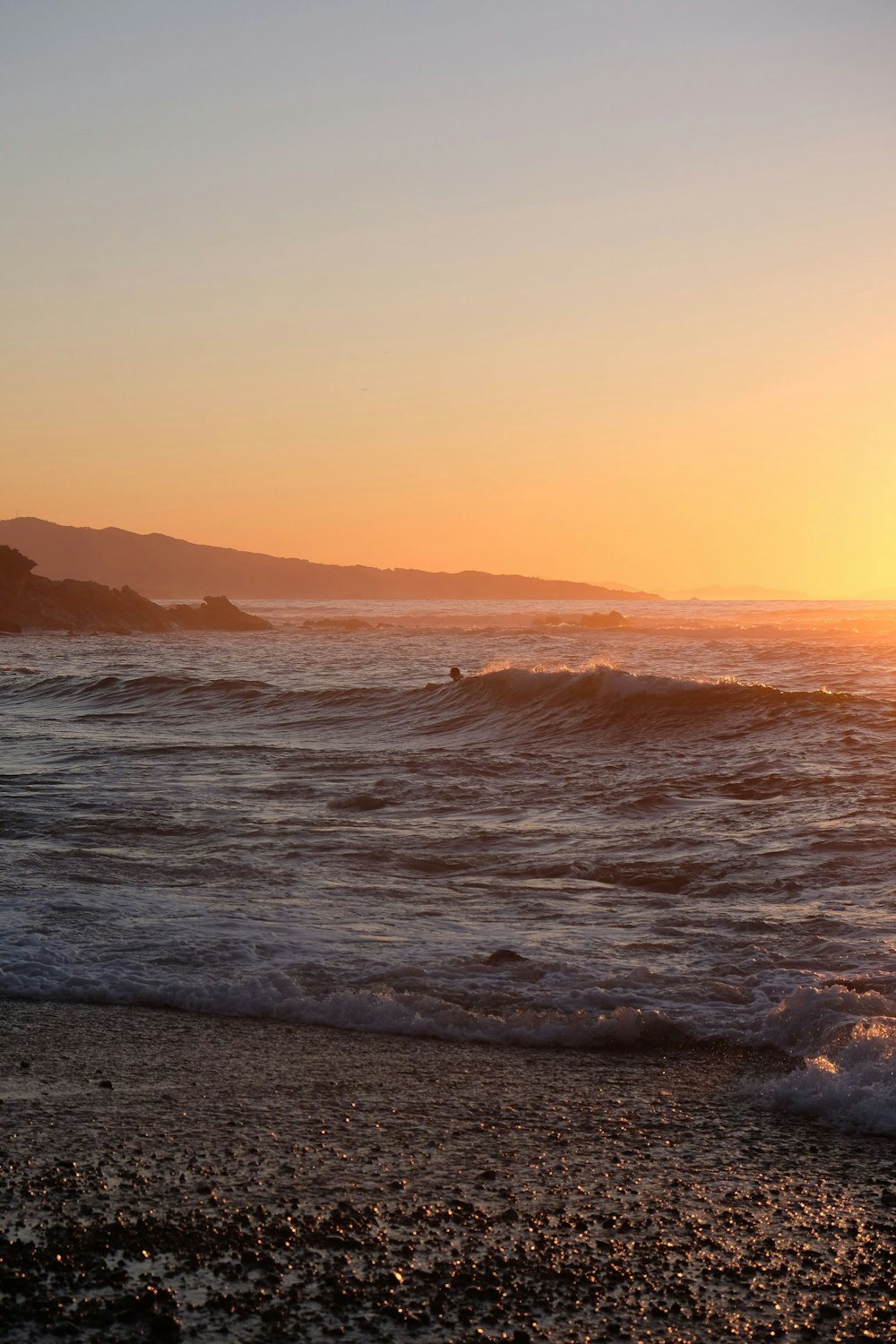 a beach with waves and a sunset