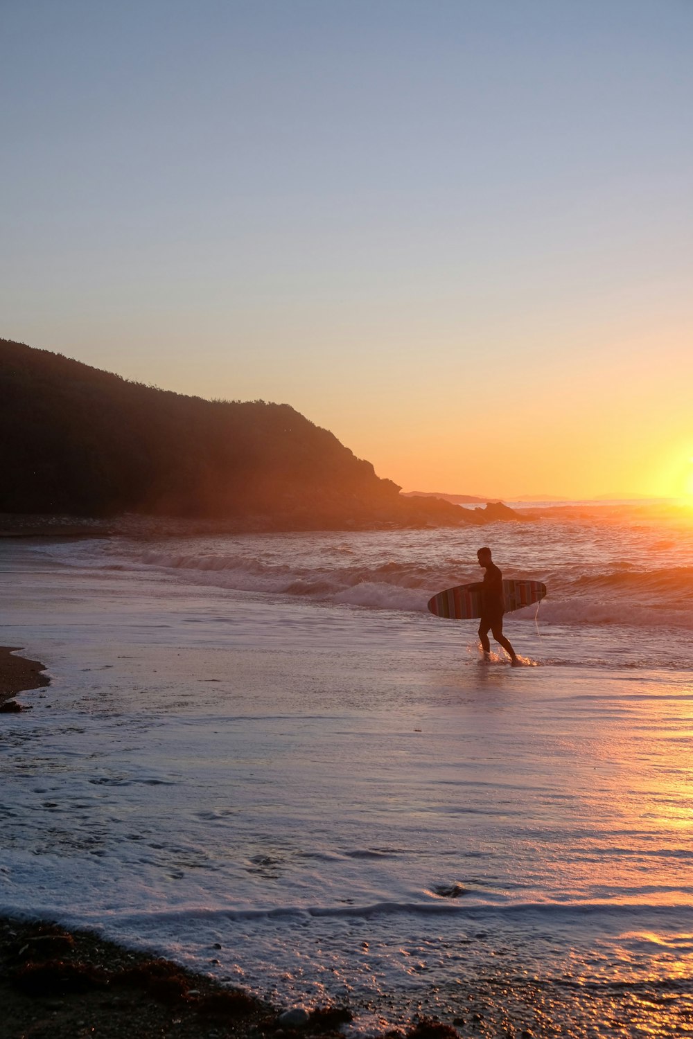 a man carrying a surfboard on the beach