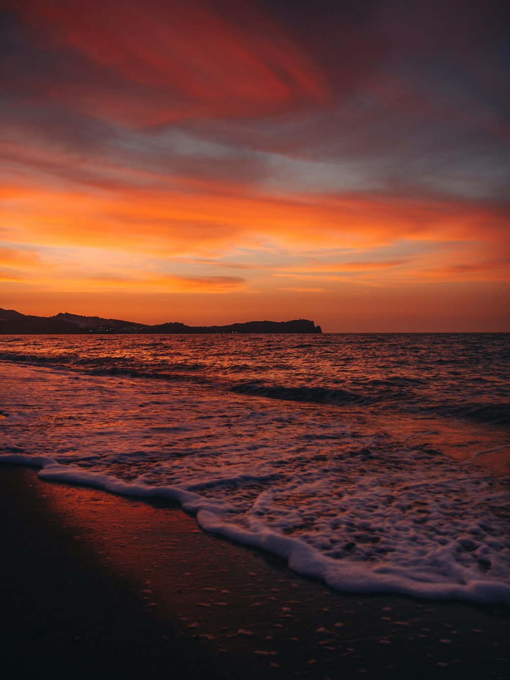 a beach with waves and a sunset