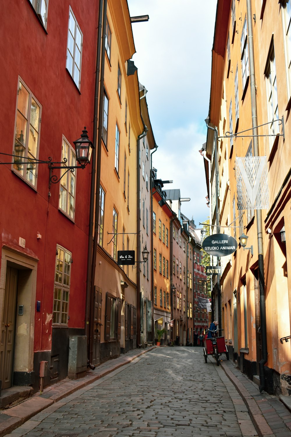 a person riding a bicycle down a narrow street