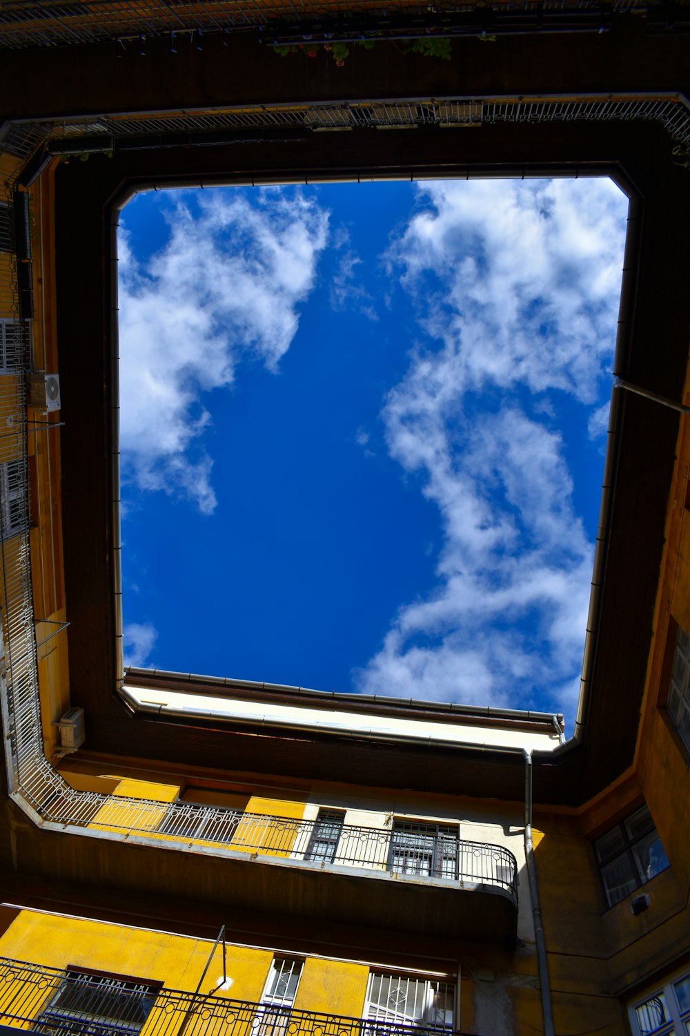 a view looking through a window at a building with a blue sky