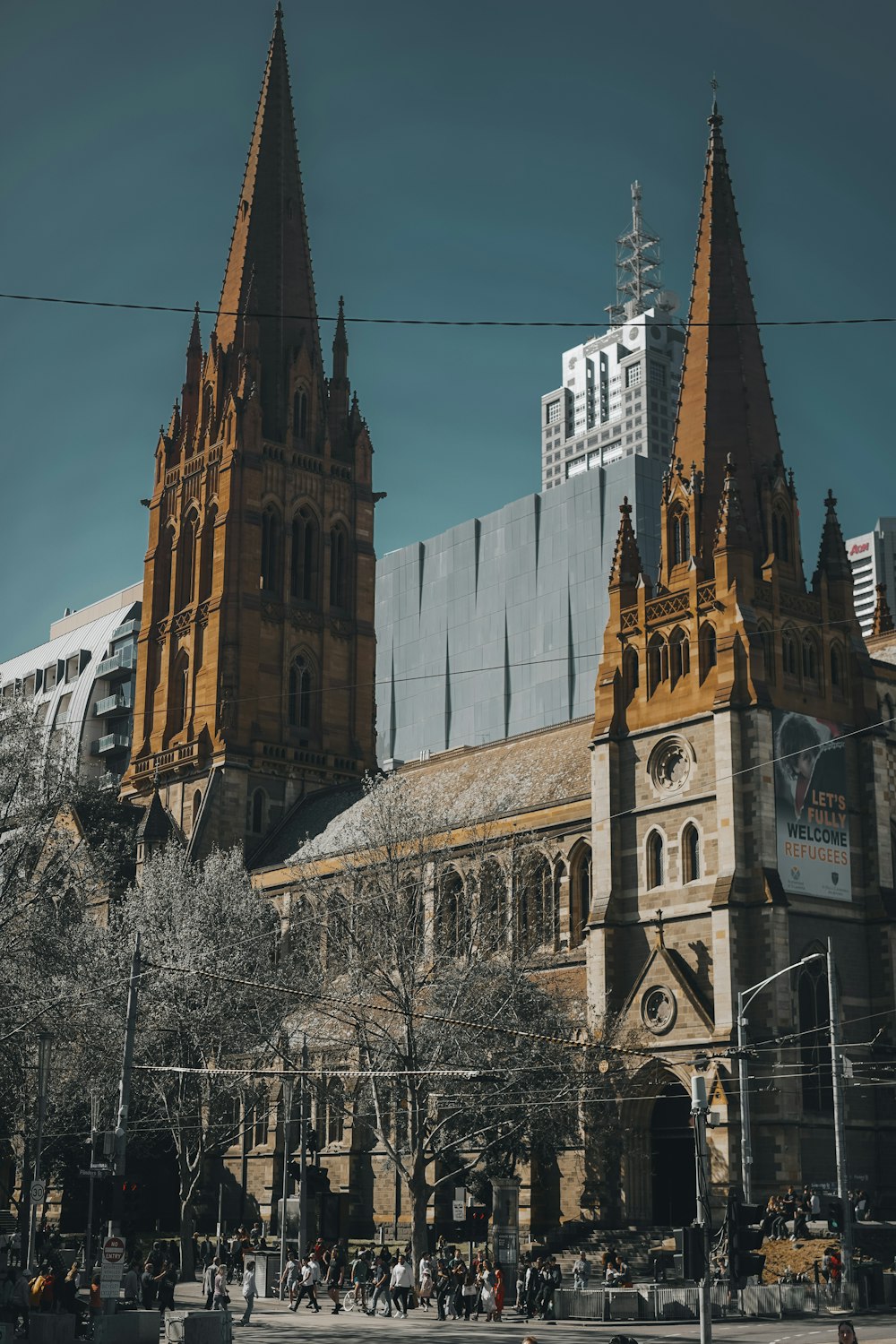 a large building with a tall tower with St Paul's Cathedral, Melbourne in the background