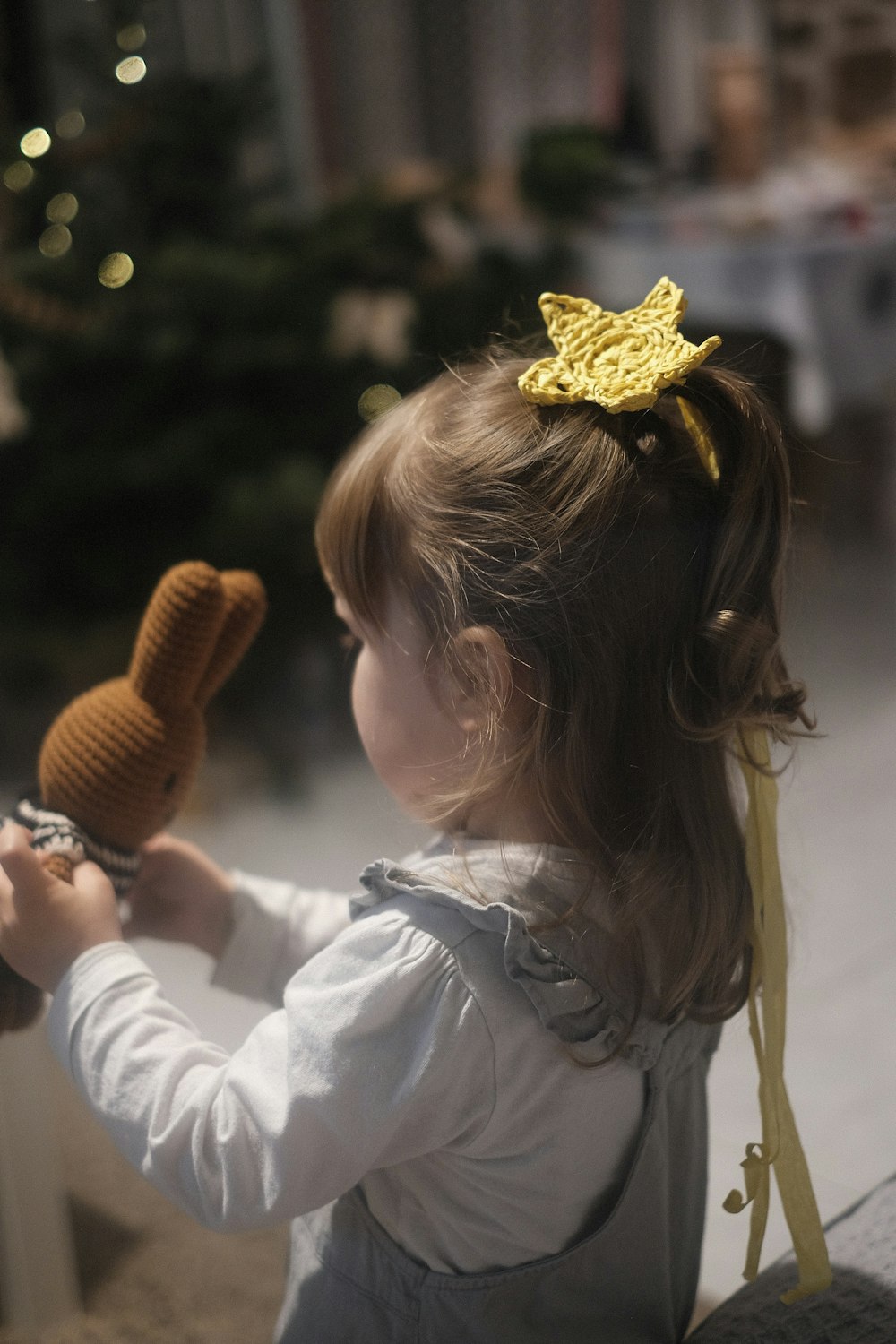 a little girl with a yellow flower in her hair