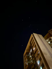 Evening shot of a nearly completed residential building with lights on.