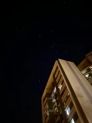 Elegant nighttime shot of a luxury residential tower with gold-lit balconies.