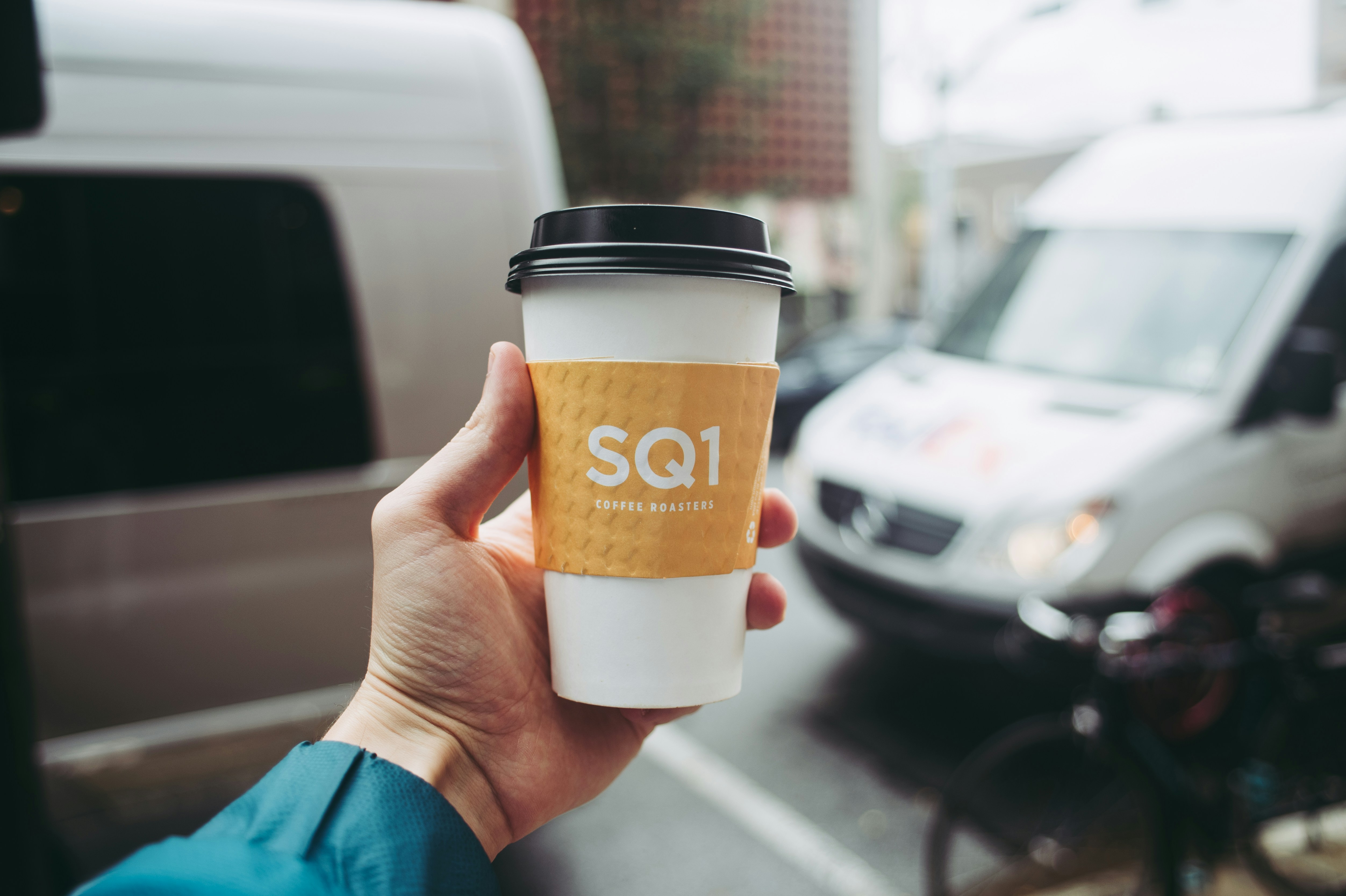 uma mão segurando uma xícara de café