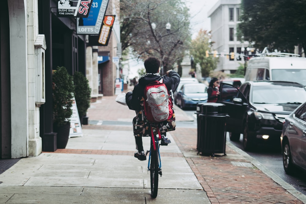 a person riding a bicycle down a sidewalk