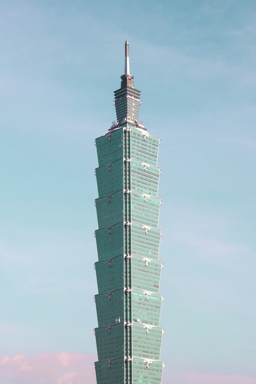 a tall building with a blue sky with Taipei 101 in the background