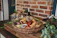 A sophisticated gift basket with wine and gourmet treats on a wooden table.