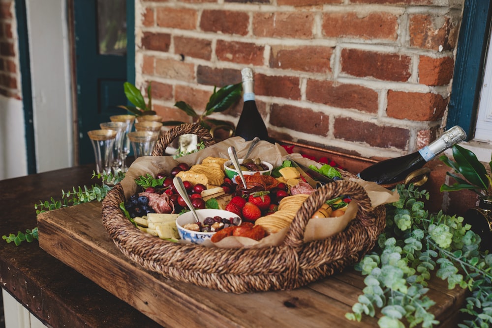 a basket of food and a bottle of wine on a table
