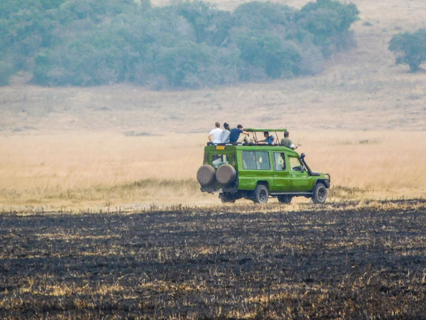 A group of people on an open safari vehicle in a field