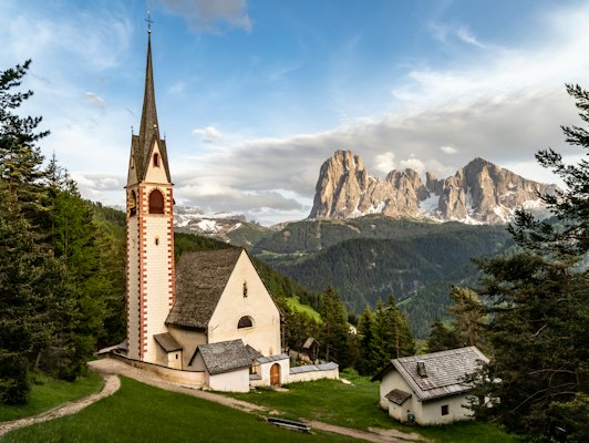 A church with a steeple and a mountain in the background — Madonna di Campiglio, Italy