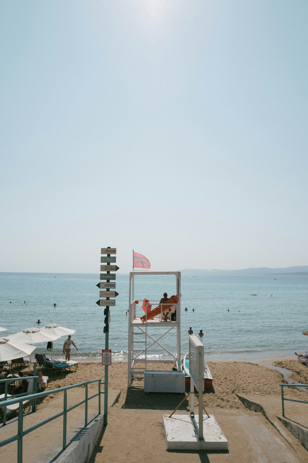 a beach with a chair and a table and chairs