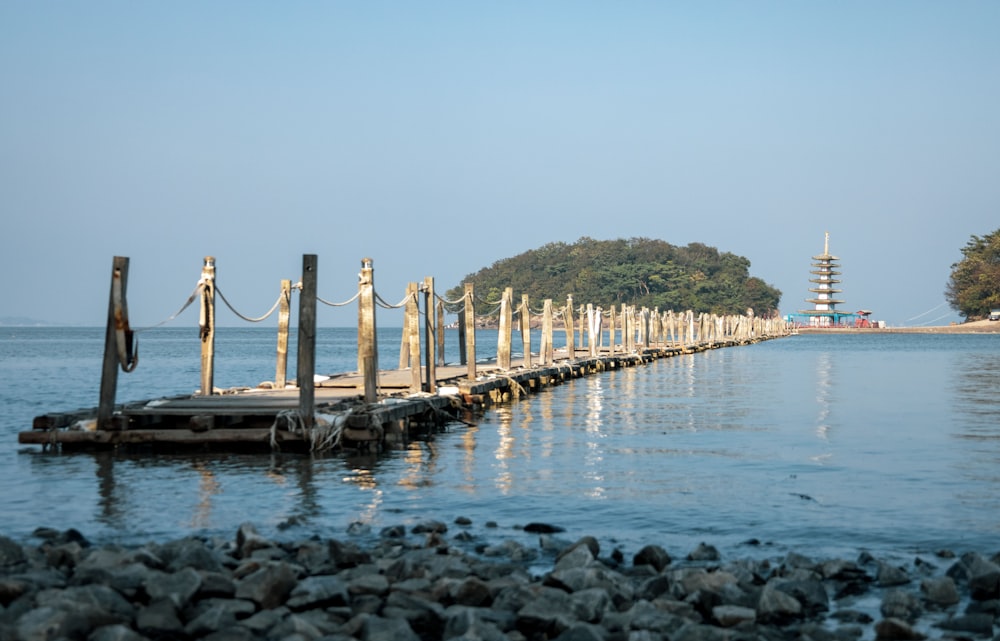a dock with rocks and a body of water with a structure in the distance