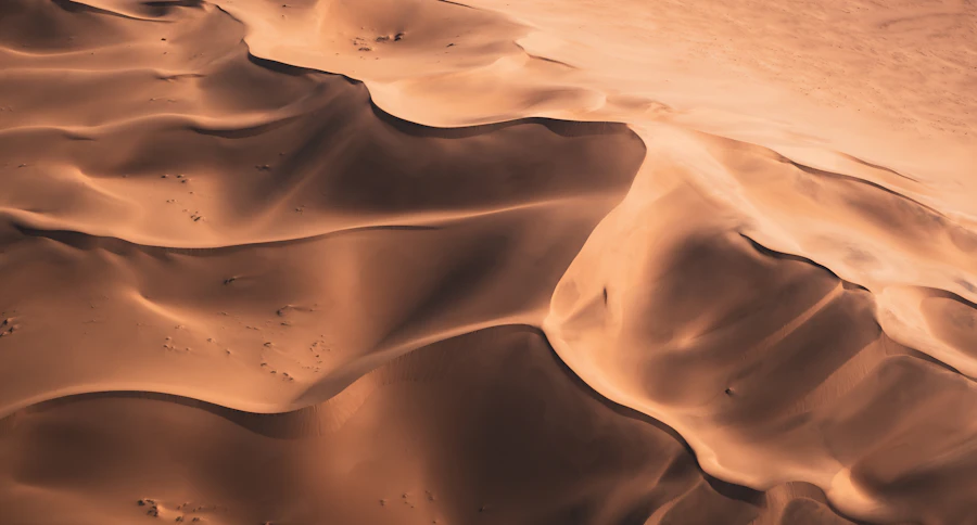 Warm aerial patterns across sculpted sand dunes