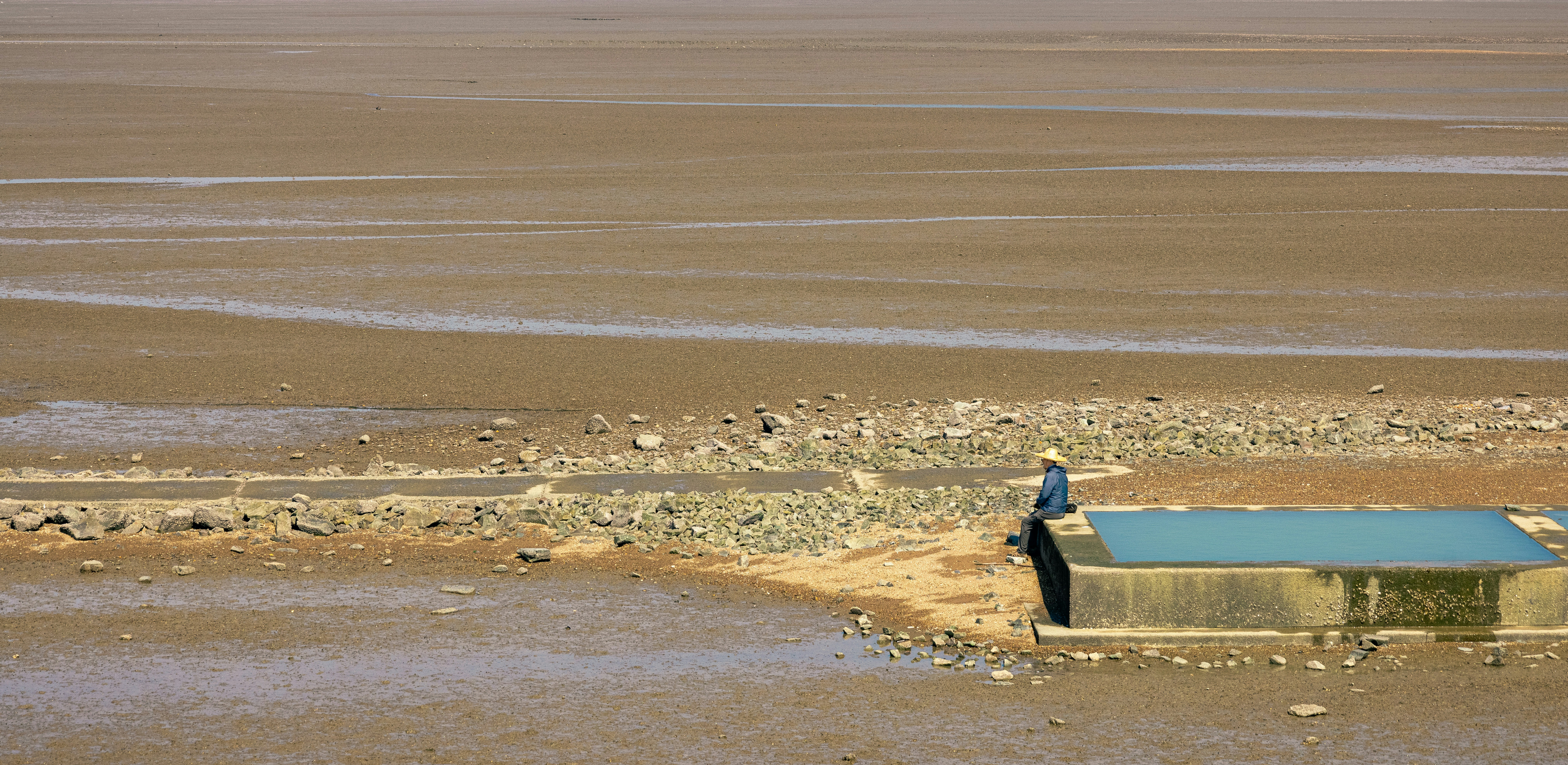 a person sitting on a bench in a beach