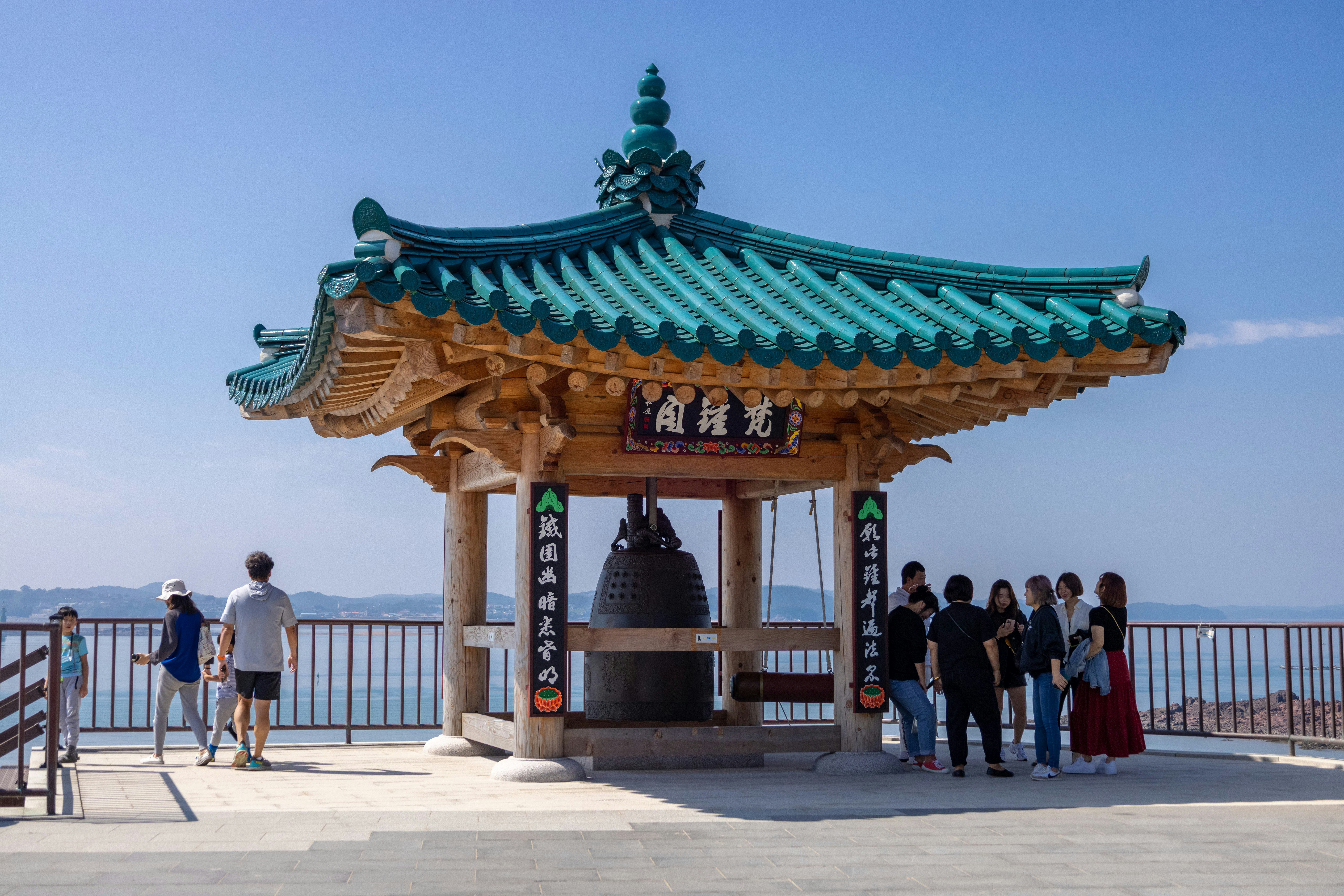 a group of people standing outside a building with a blue roof