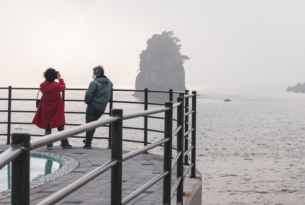 a man and woman walking on a bridge over water