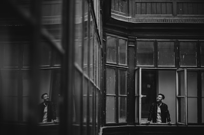 a couple of men standing in a window