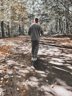 A model wearing a stylish tracksuit walking through a misty park in autumn.