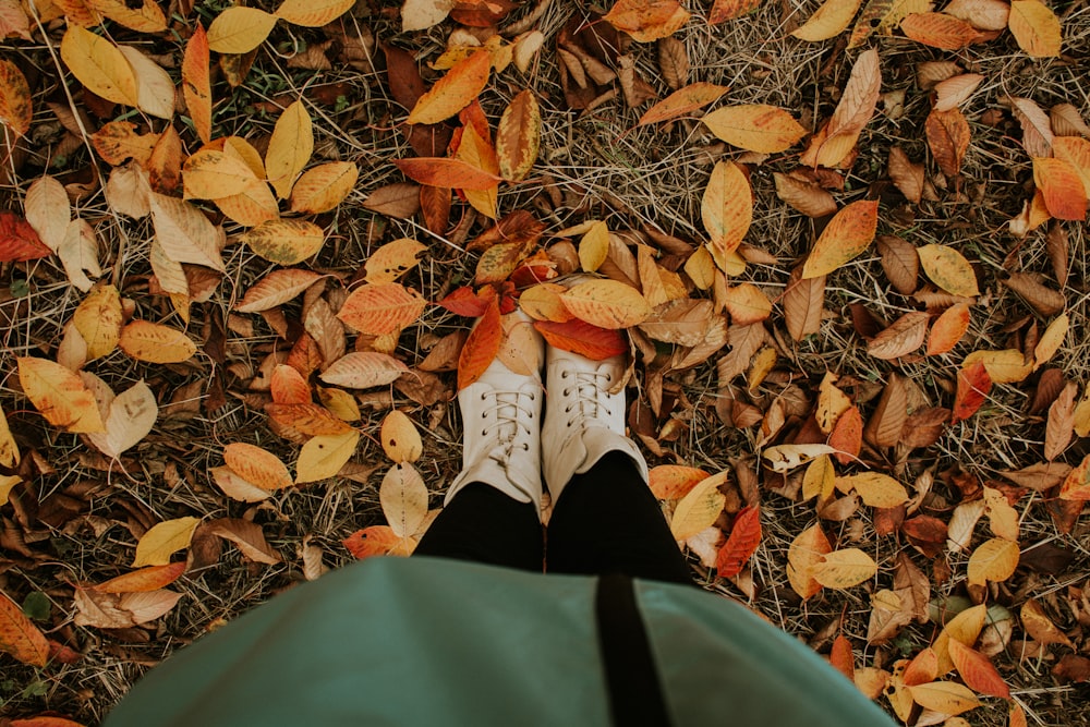 a person's feet in a pile of leaves