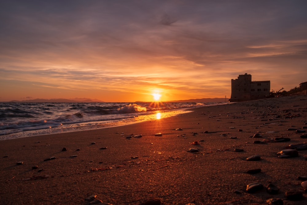 a beach with a building and water