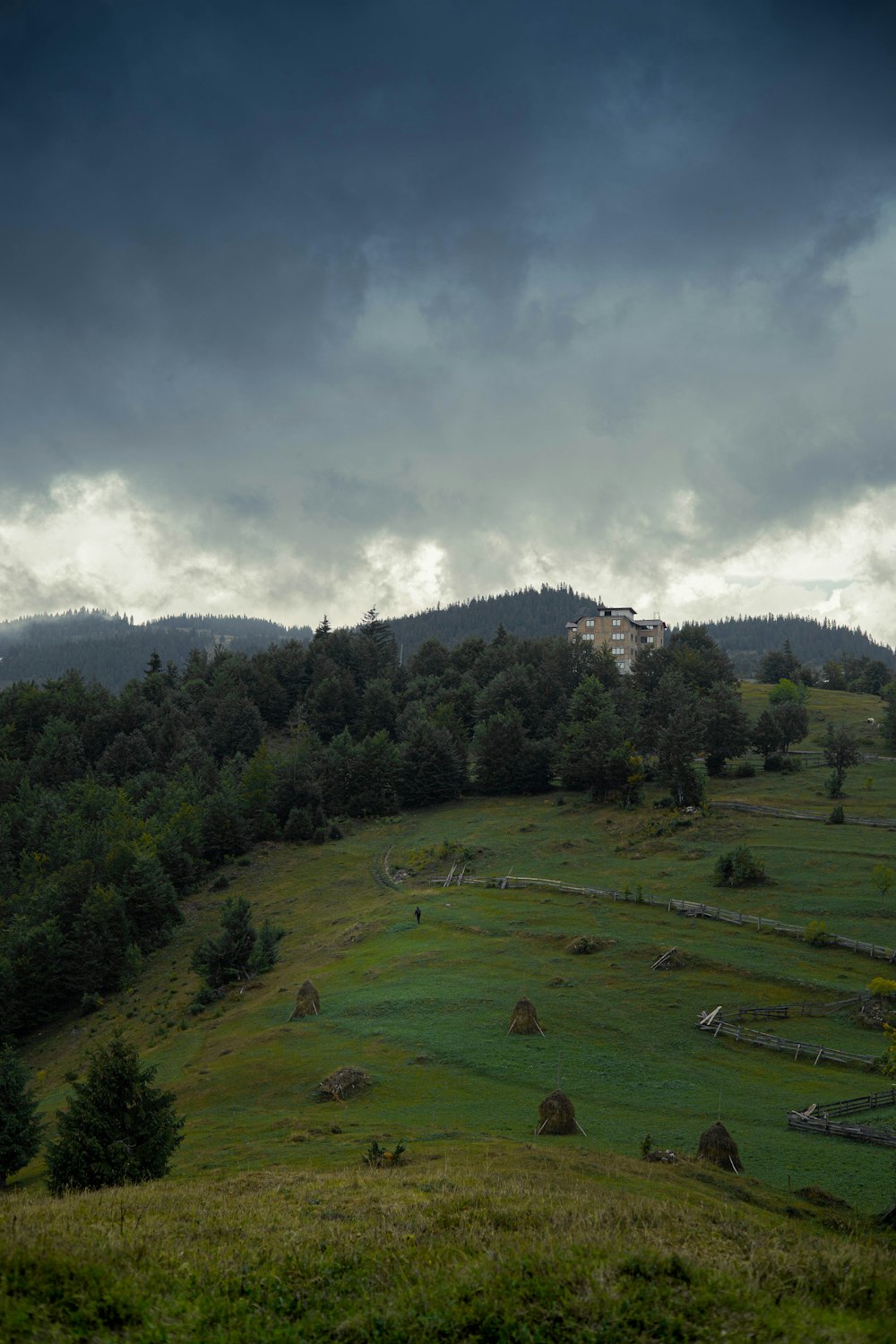 a large green landscape with a building in the distance