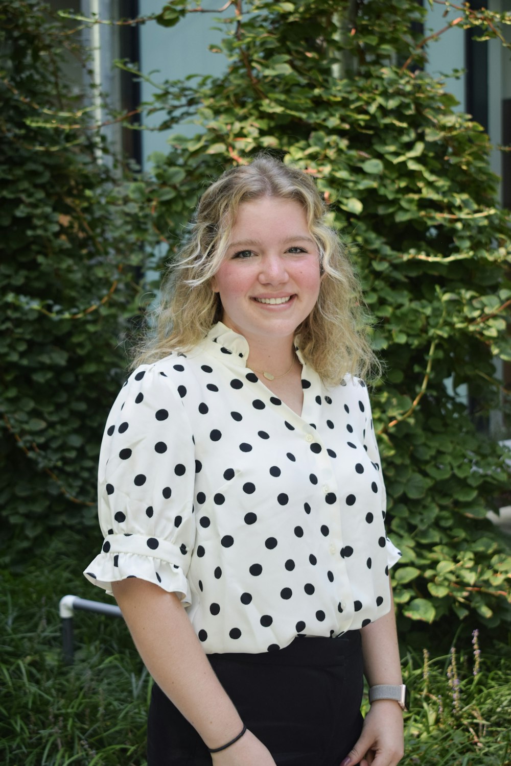 a person smiling in front of a tree