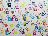 Close-up of colorful handprints overlapping on a canvas.