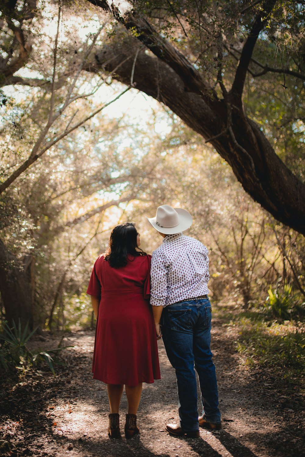 a man and woman kissing under a tree