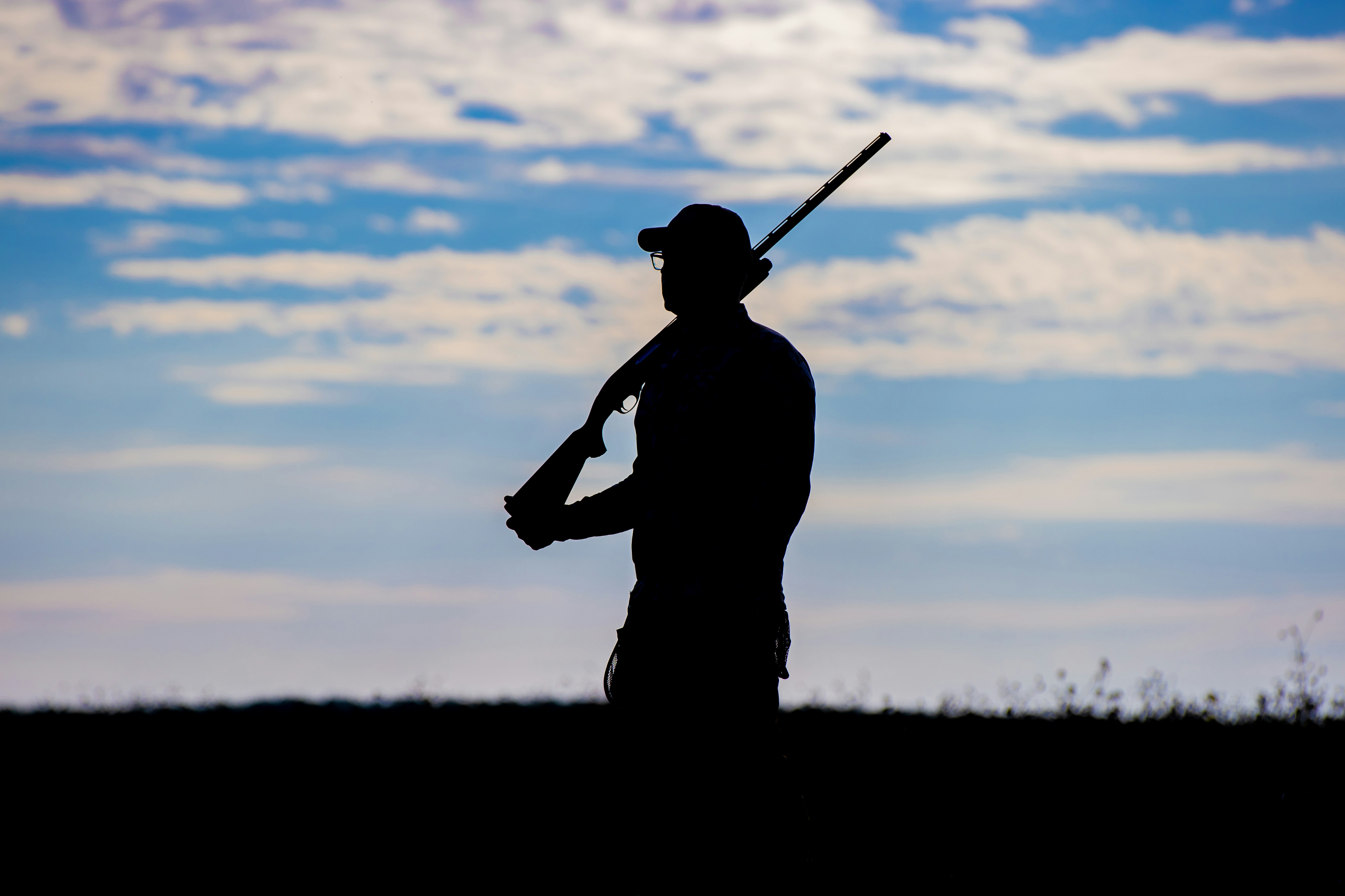 a silhouette of a man holding a gun