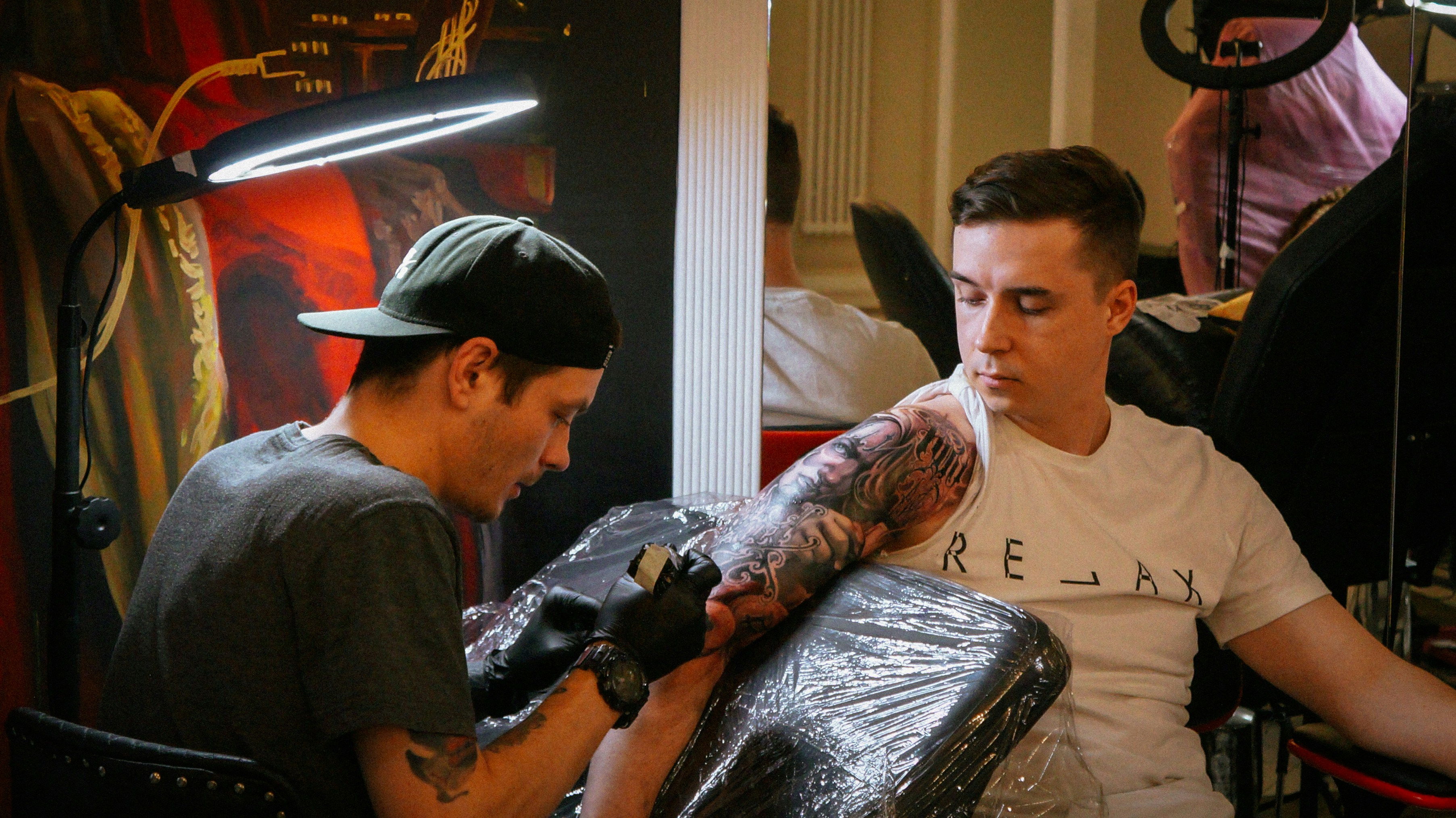 a man holding a gun next to a man with a hat